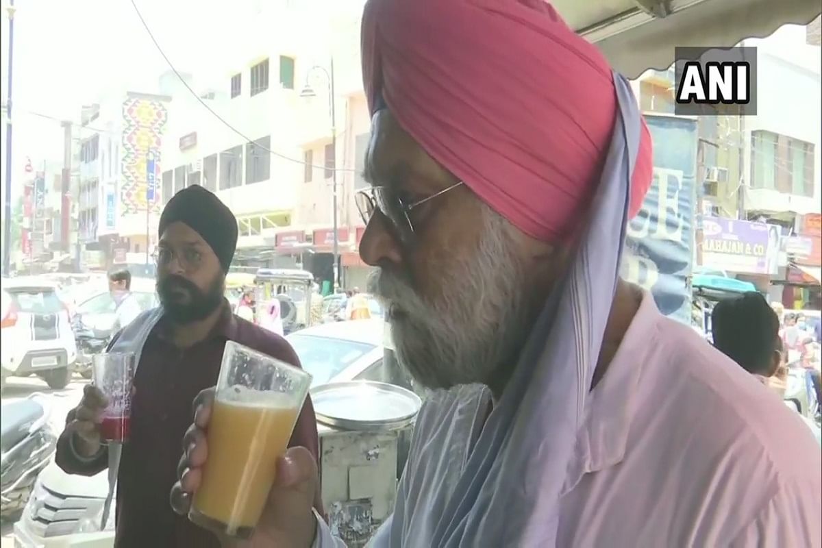 जूस से अपनी प्यास बुझाने की कोशिश करते लोग