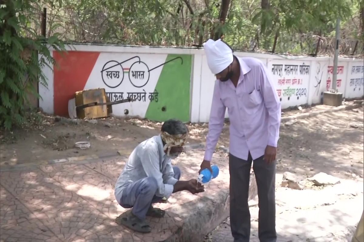 राहगीर की प्यास बुझाता व्यक्ति