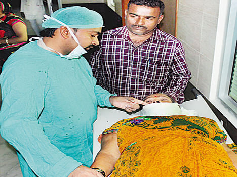 मेडिकल कॉलेज में कैंसर पीड़ित महिला का ऑपरेशन करने के बाद ड्रेसिंग करते डॉ.भूपेंद्र सिंह। 