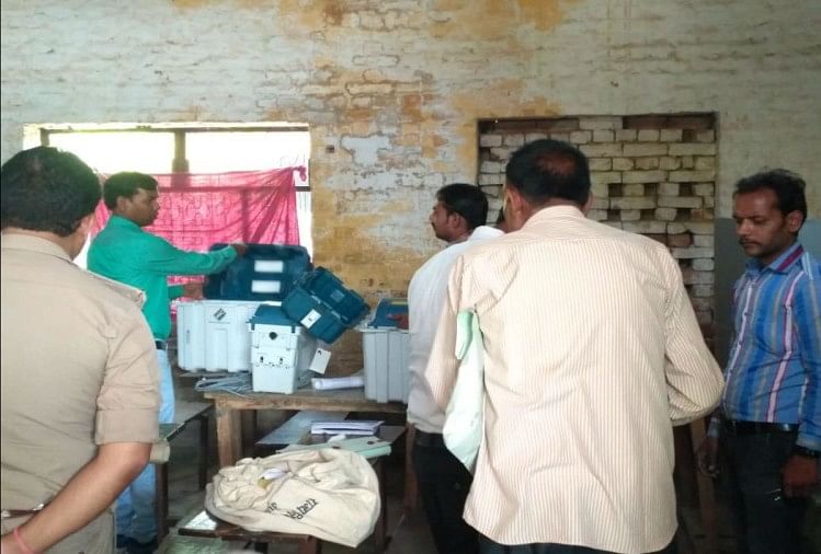 मैनपुरी के चित्रगुप्त इंटर कॉलेज में दूसरी ईवीएम लगाते कर्मचारी