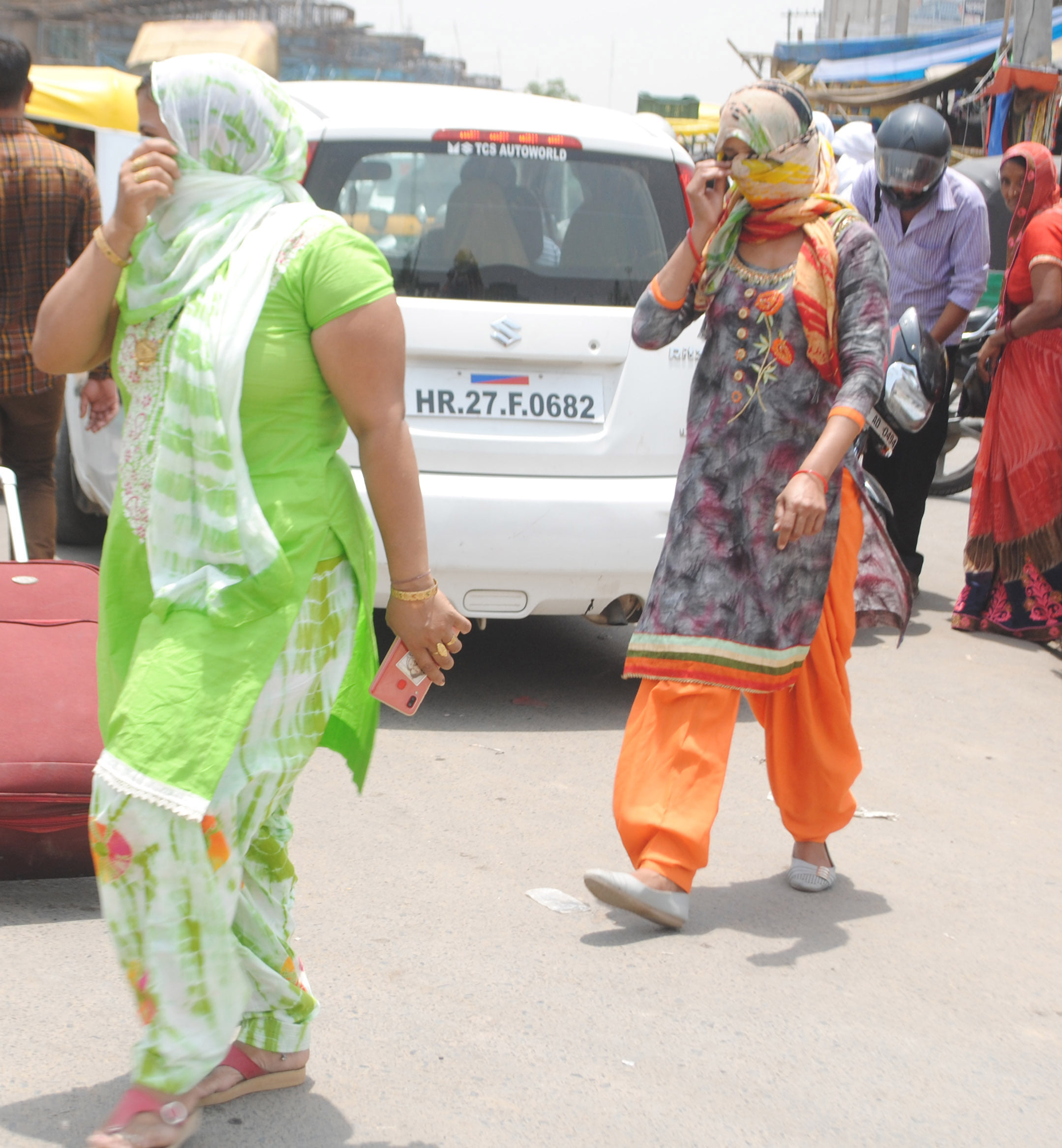 गर्मी से बचने के लिए मुंह पर कपड़ा बांधकर निकलती महिलाएं गर्मी से बचने के लिए मुंह पर कपड़ा बांधकर निकलती महिलाएं