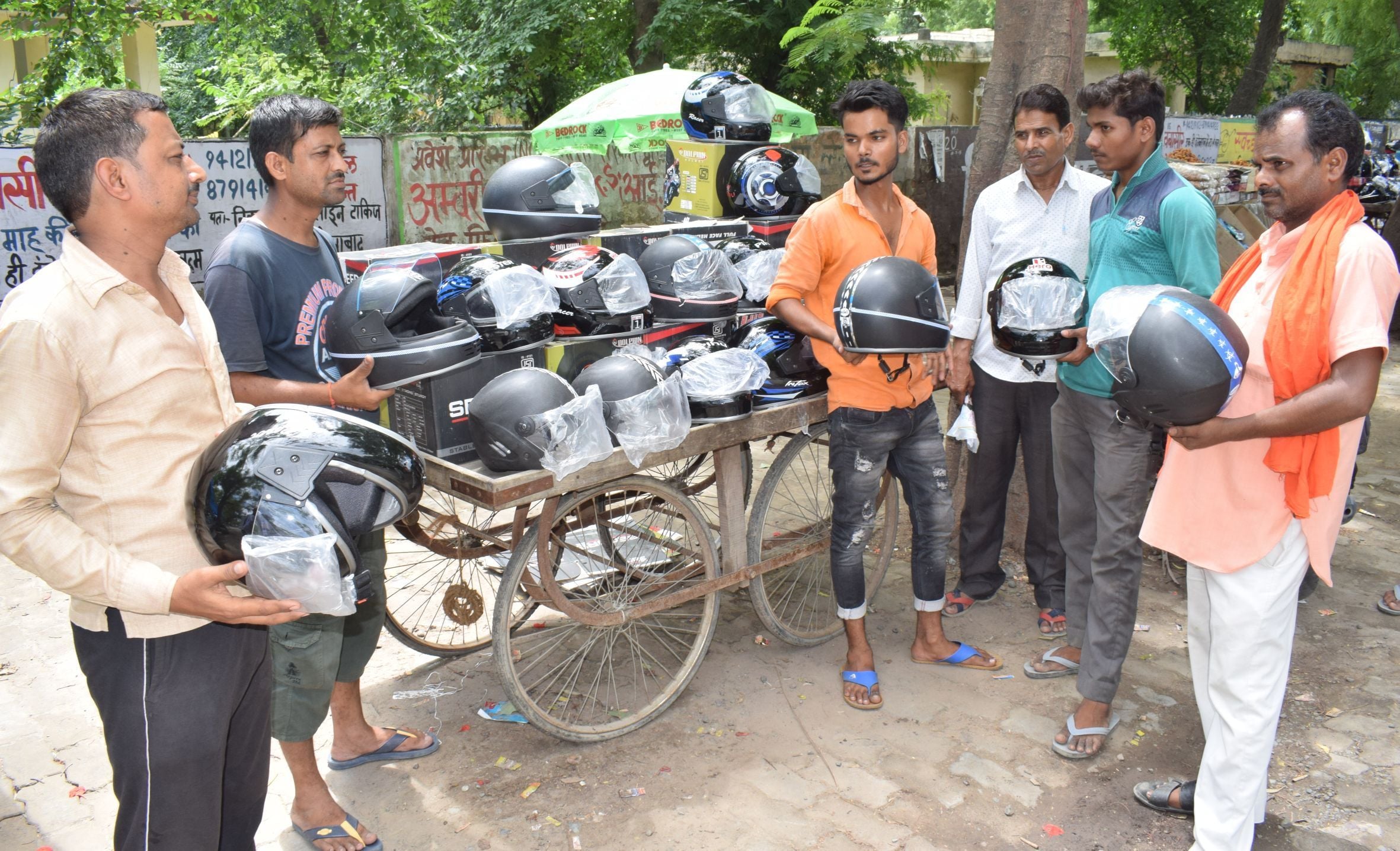 हरदोई में कचहरी रोड पर ठेले पर हेलमेट खरीदते लोग। अमर उजाला