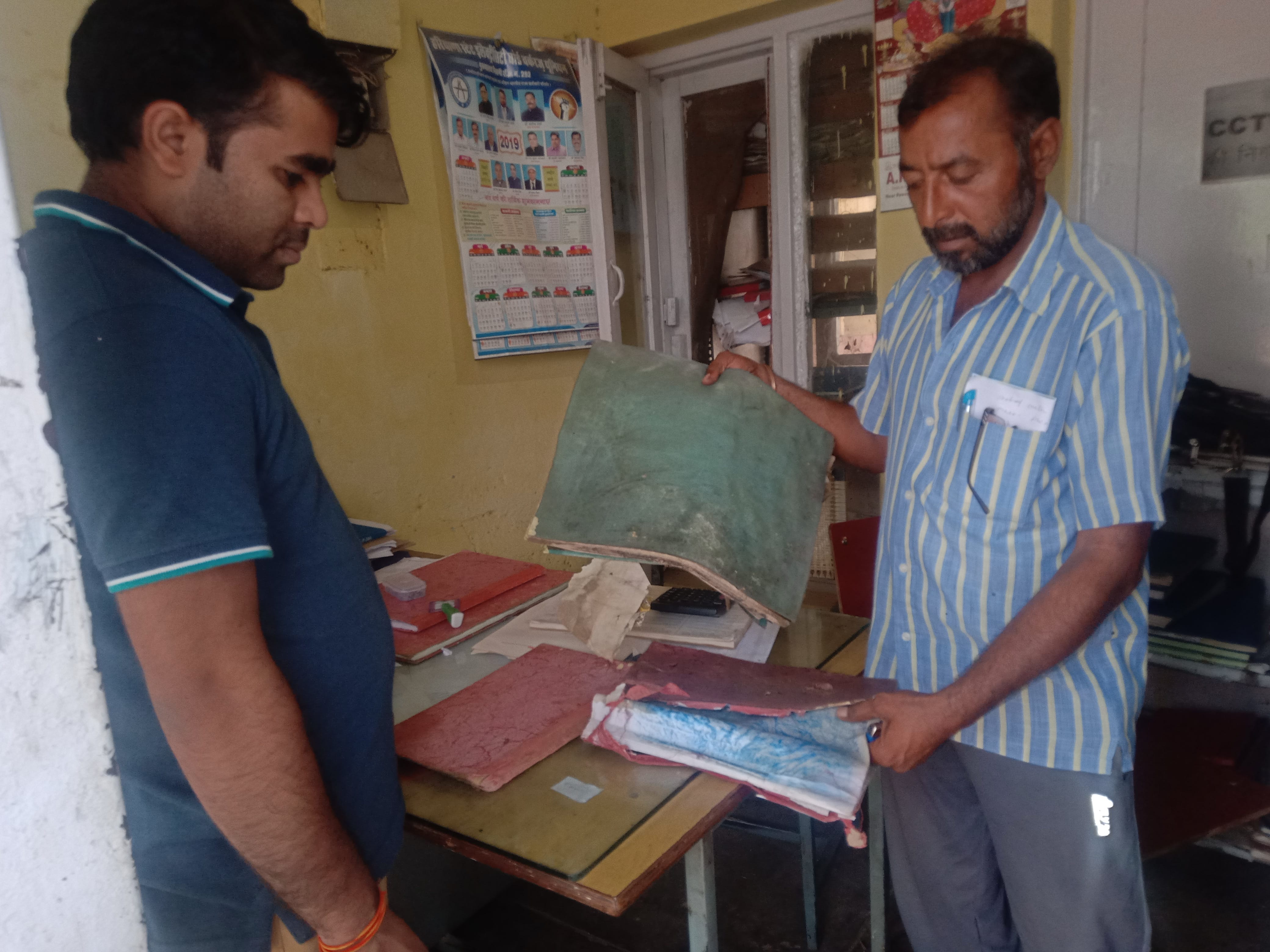 फोटो संख्या:64- बिजली कार्यालय कनीना में बारिश में भीगे हुए रिकार्ड को दिखाते हुए कर्मचारी फोटो संख्या:64- बिजली कार्यालय कनीना में बारिश में भीगे हुए रिकार्ड को दिखाते हुए कर्मचारी