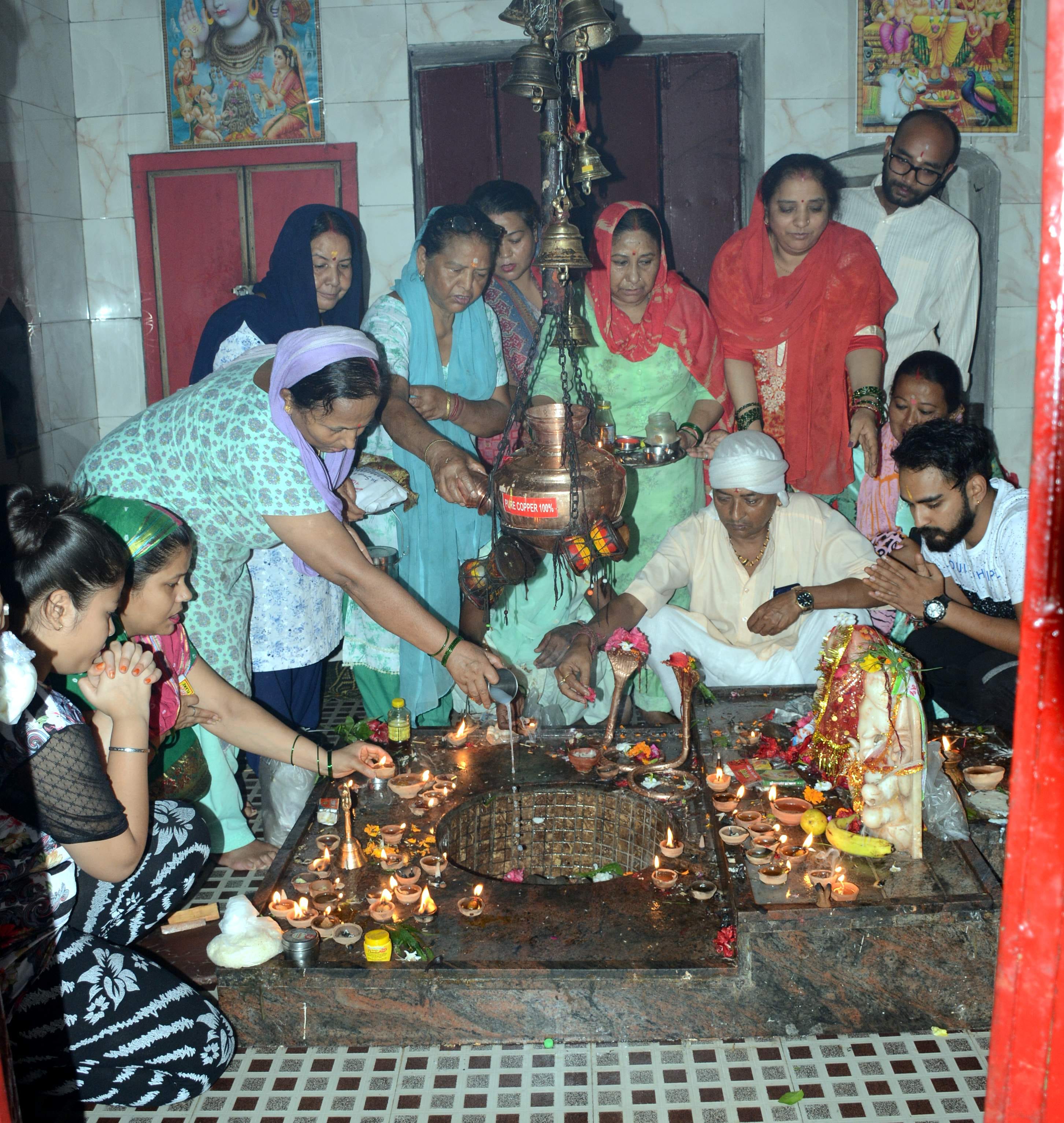 शिवरात्रि के अवसर पर नागेश्वर महादेव मंदिर में जलाभिषेक करते श्रद्धालु । 