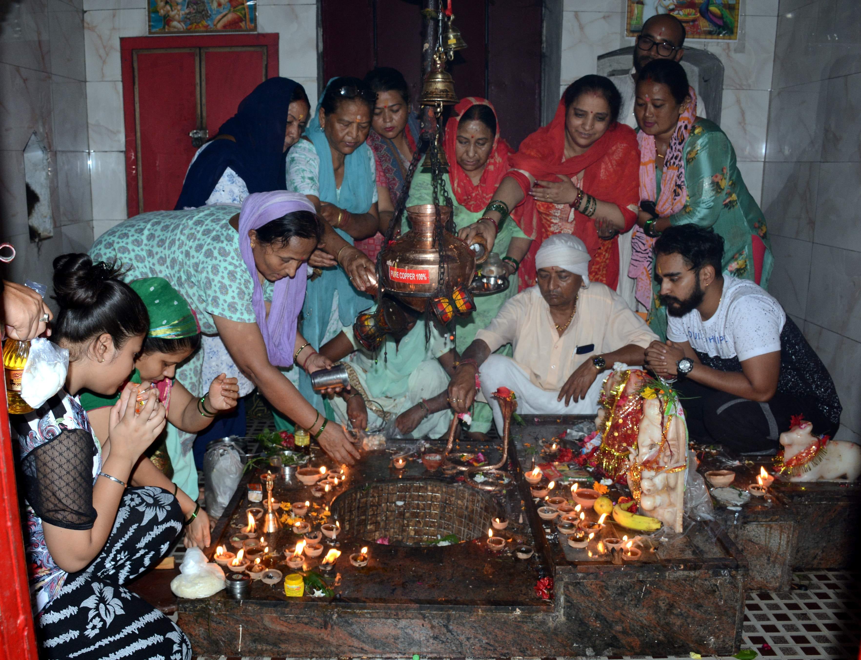 शिवरात्रि के अवसर पर नागेश्वर महादेव मंदिर में जलाभिषेक करते श्रद्धालु । 