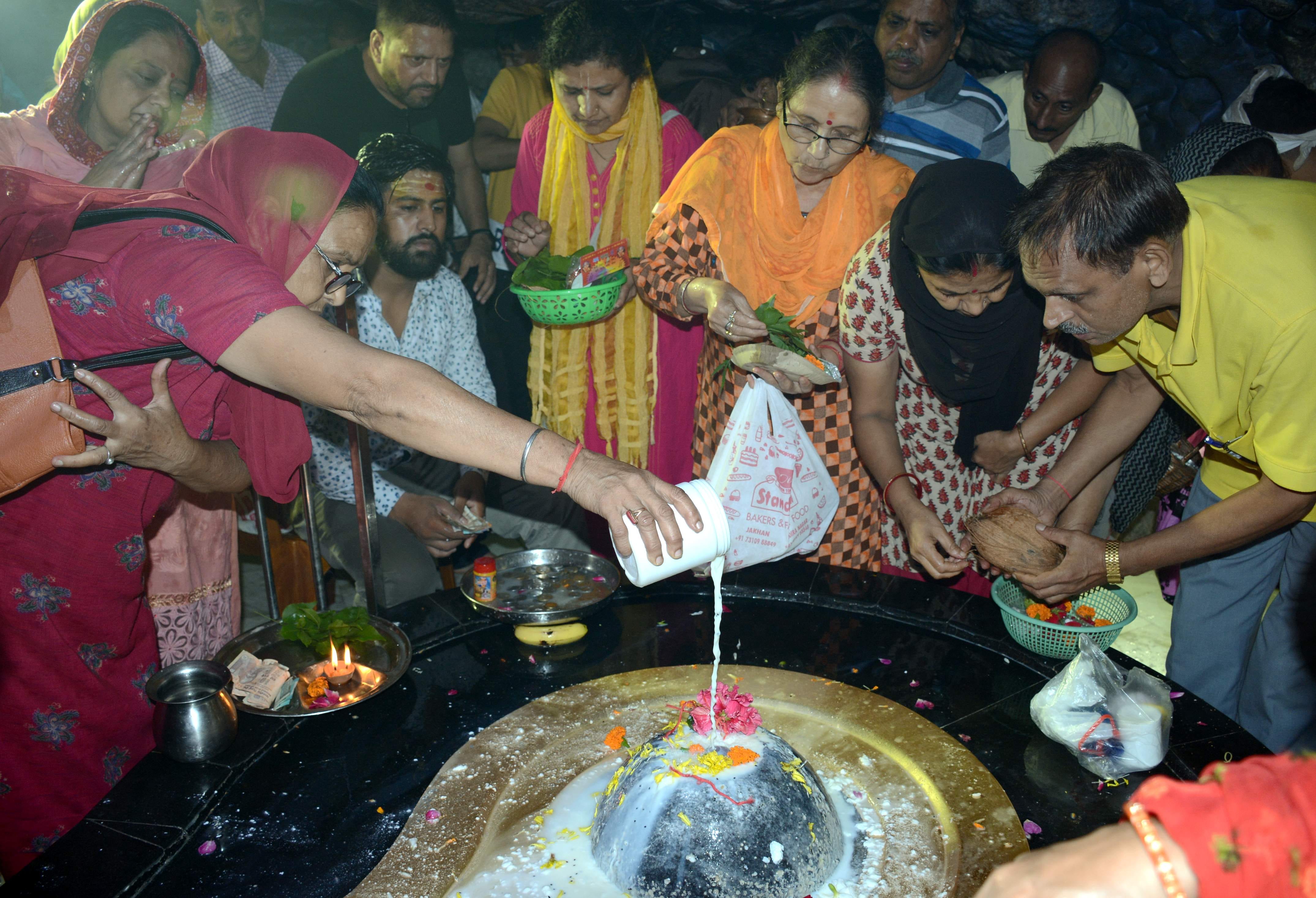 शिवरात्रि के अवसर पर टपकेश्वर महादेव मंदिर में जलाभिषेक करते श्रद्धालु । 