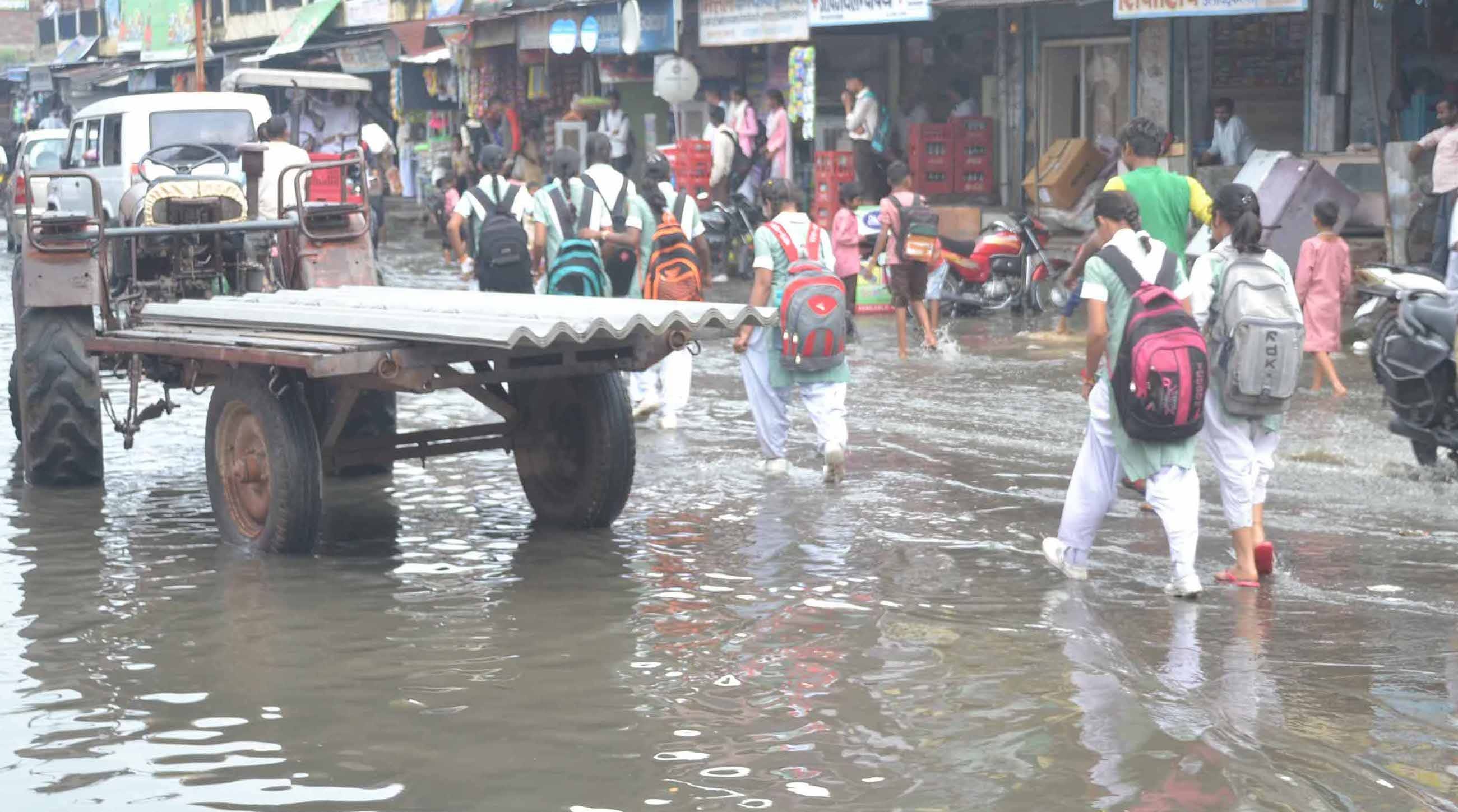शामली मिल रोड पर भरे पानी में गुजरती छात्राऐ