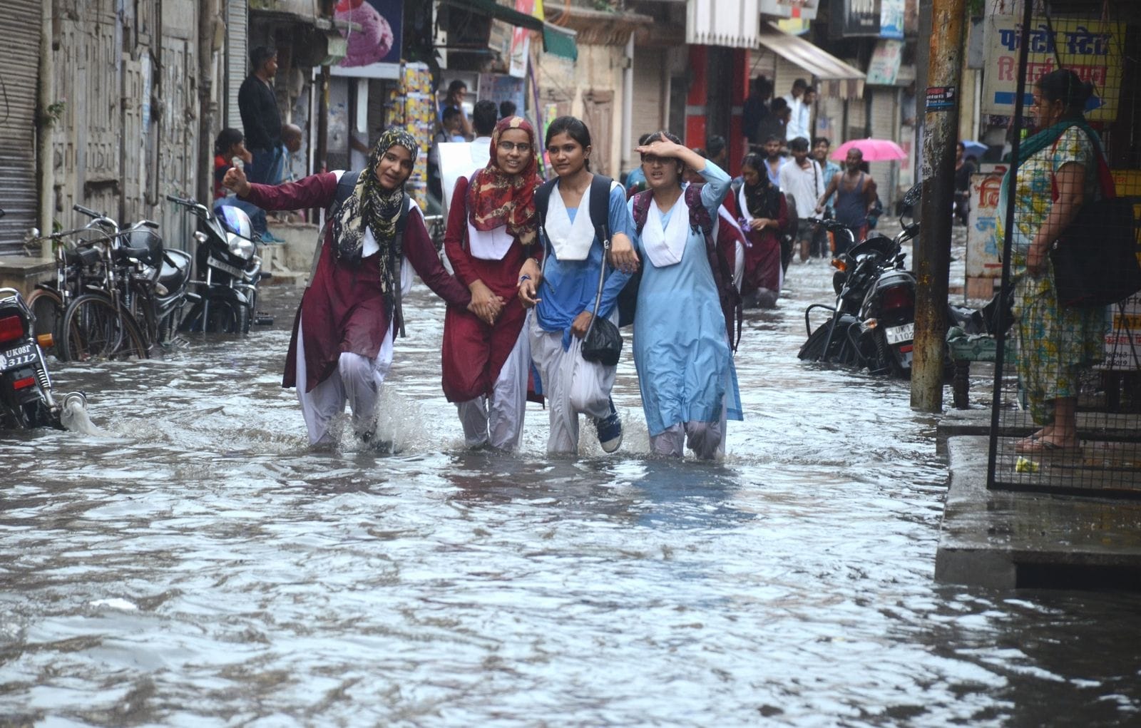 रुड़की में दोपहर से समय हुई तेज बारिश के कारण अंबर तालाब में हुए जलभराव के बीच से गुजरती स्कूली छा?