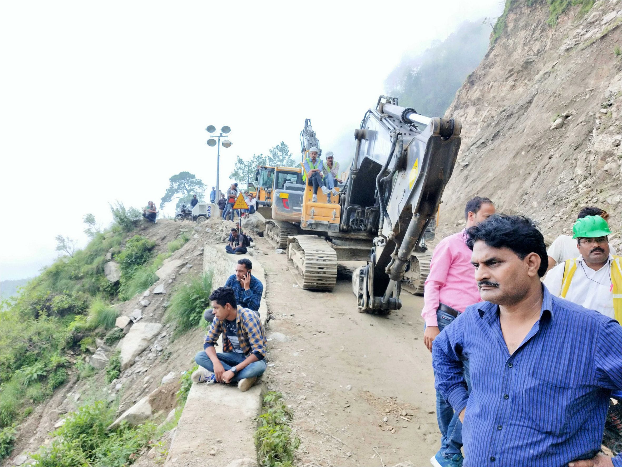 एनएच में धौन के पास सड़क खुलने का इंतजार करते यात्री।