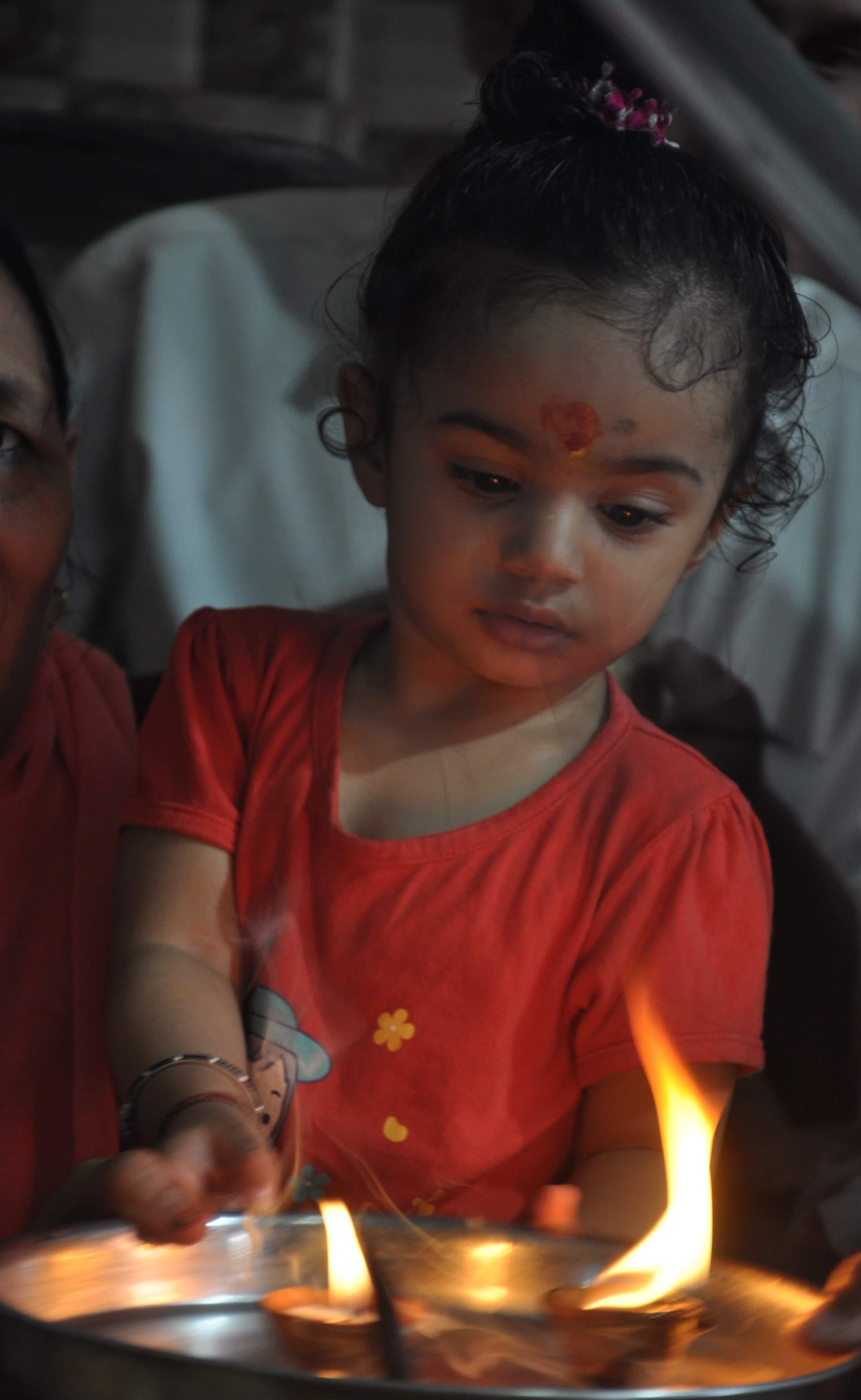 सावन पर्व के अवसर पर आराघर स्थित पंचायती मंदिर में जलाभिषेक के बाद दीया जलाती बच्ची सावन पर्व के अवसर पर आराघर स्थित पंचायती मंदिर में जलाभिषेक के बाद दीया जलाती बच्ची