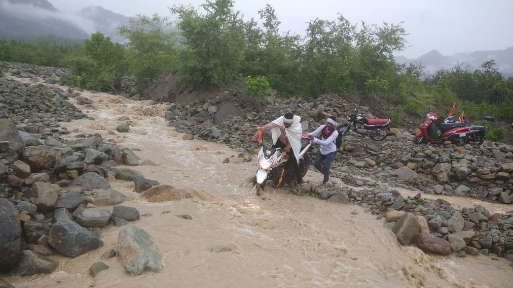पूर्णागिरि धाम मार्ग में बाटनागाड़ में आए मलवे से जोखिम उठाकर बाइक निकालते यात्री। पूर्णागिरि धाम मार्ग में बाटनागाड़ में आए मलवे से जोखिम उठाकर बाइक निकालते यात्री।