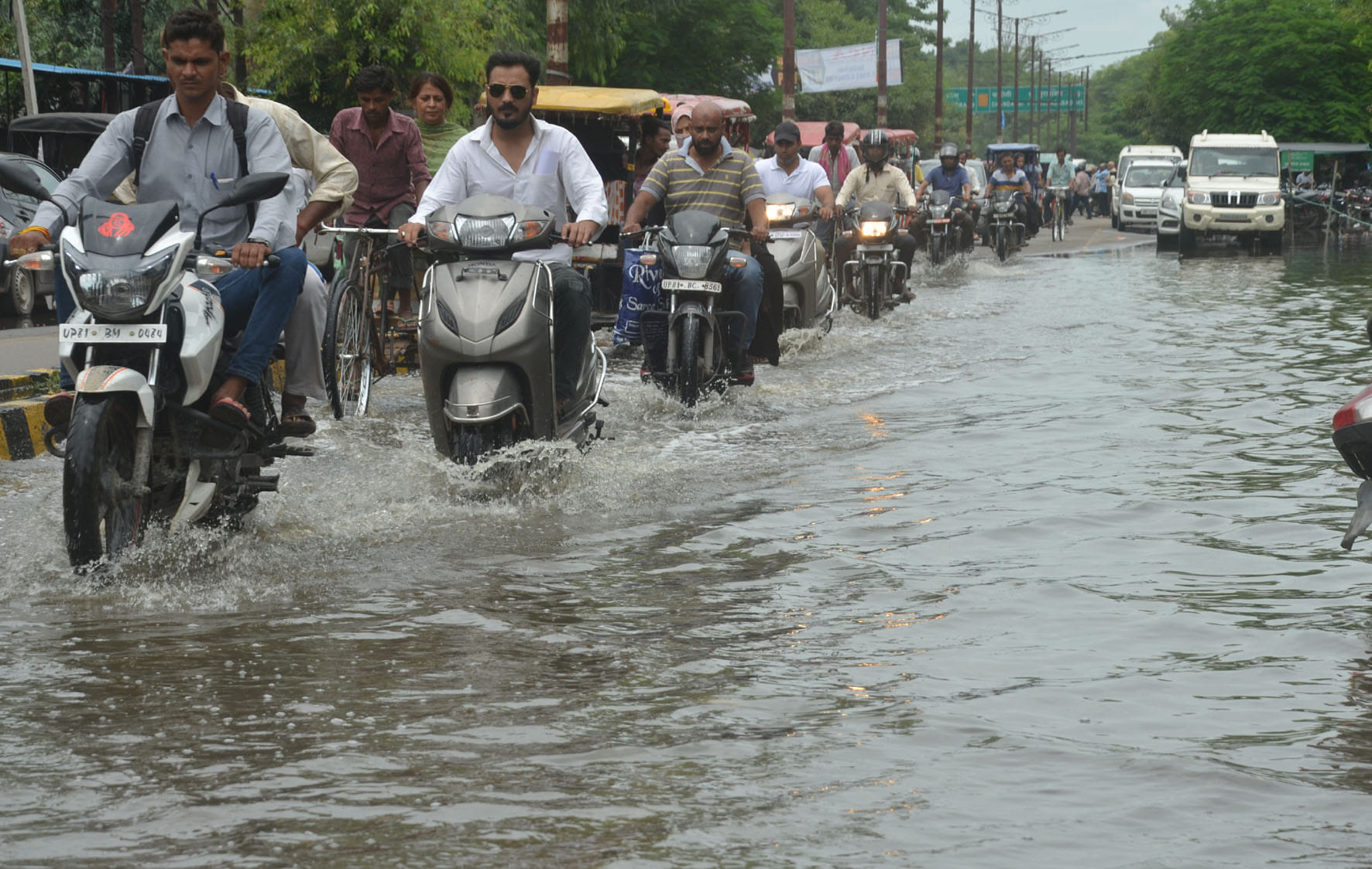  कचहरी रोड पर हुए जलभराव में होकर गुजरते लोग।
