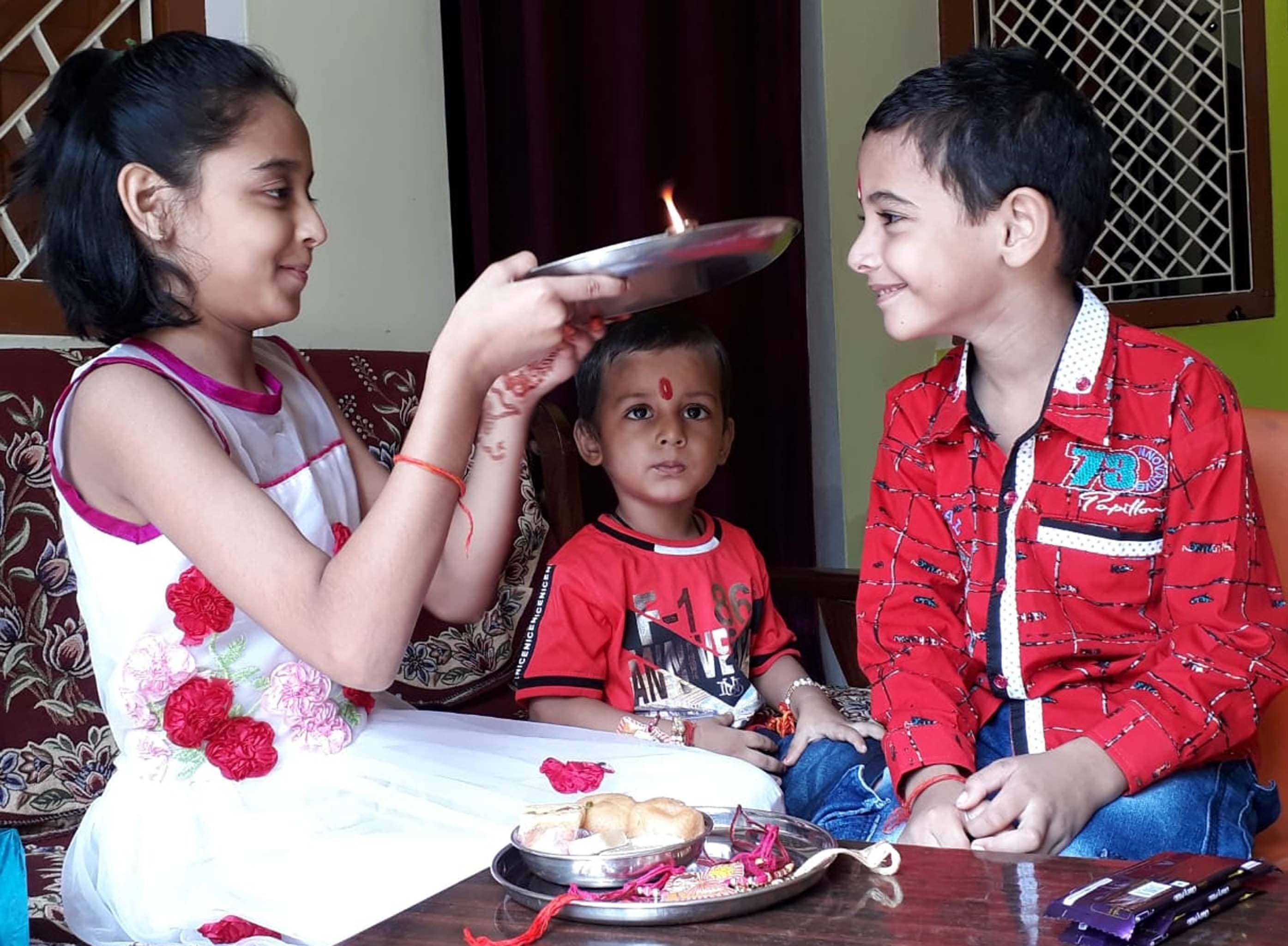 दिलीपपुर में रक्षाबंधन पर छोटे भाईयों की आरती करती बहन।