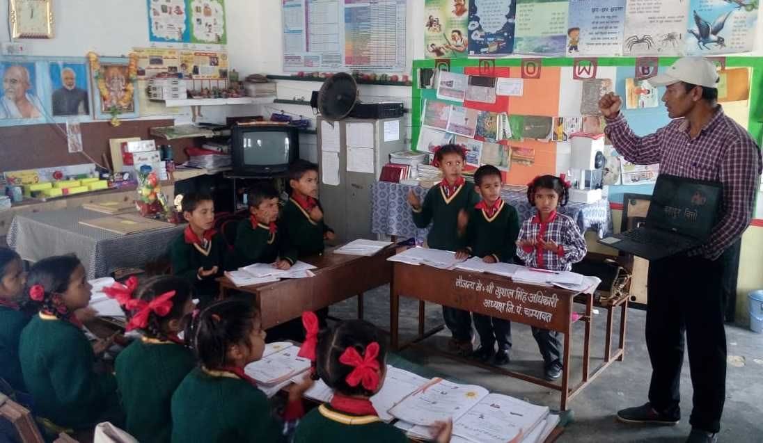 लैपटॉप के जरिए छात्र छात्राओं को पढ़ाते शिक्षक शंकर सिंह अधिकारी।
