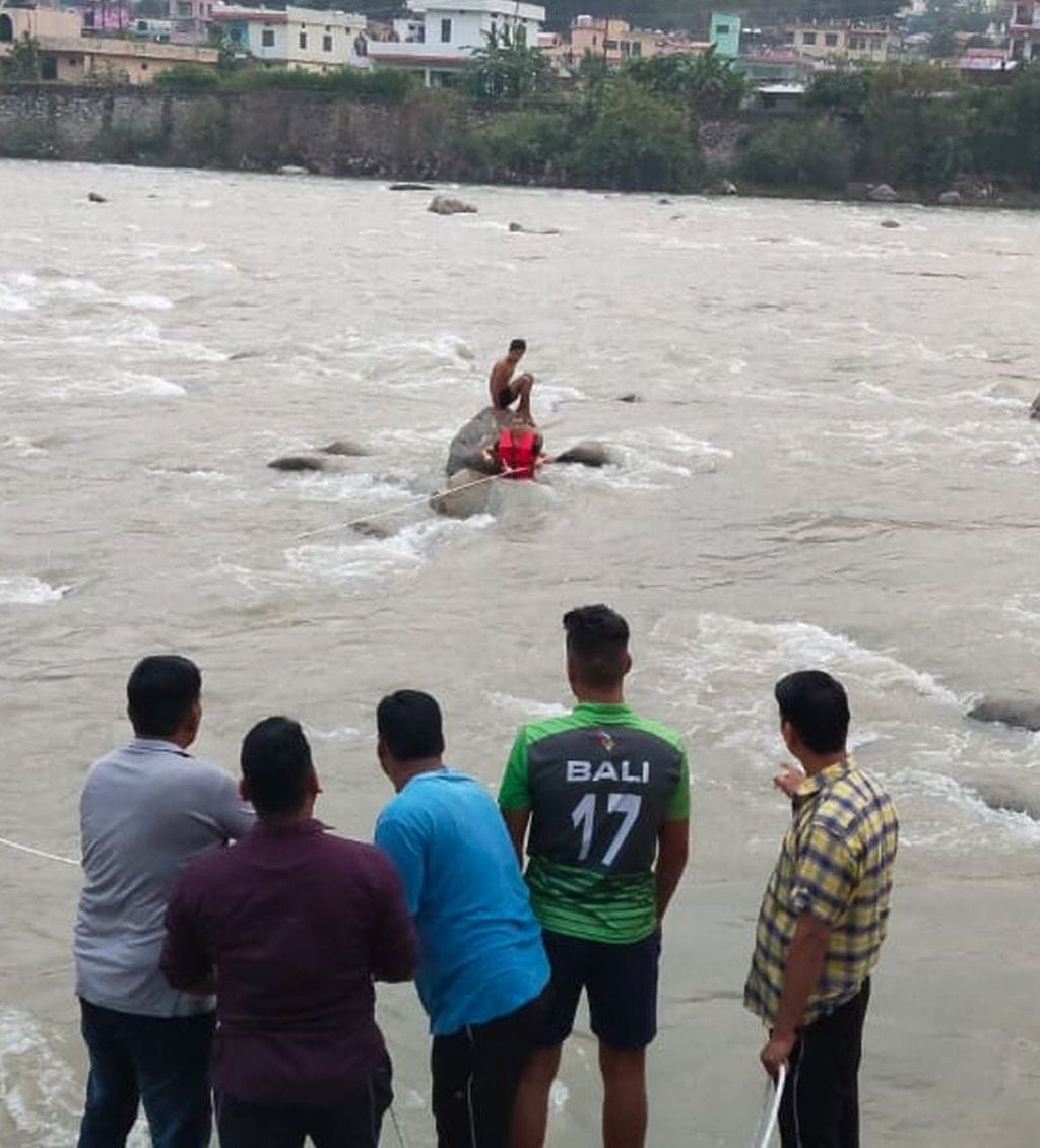 सरयू नदी के बीच बोल्डर पर बैठा फुटबाल खिलाड़ी विनोद रावल। सरयू नदी के बीच बोल्डर पर बैठा फुटबाल खिलाड़ी विनोद रावल।