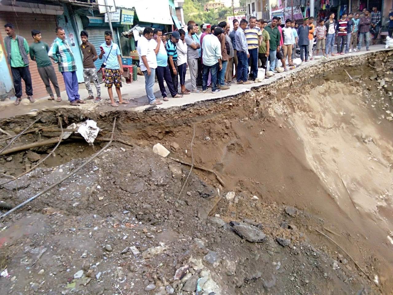 साहिया में भूस्खलन की जद में आई सड़क को देखते लोग। साहिया में भूस्खलन की जद में आई सड़क को देखते लोग।