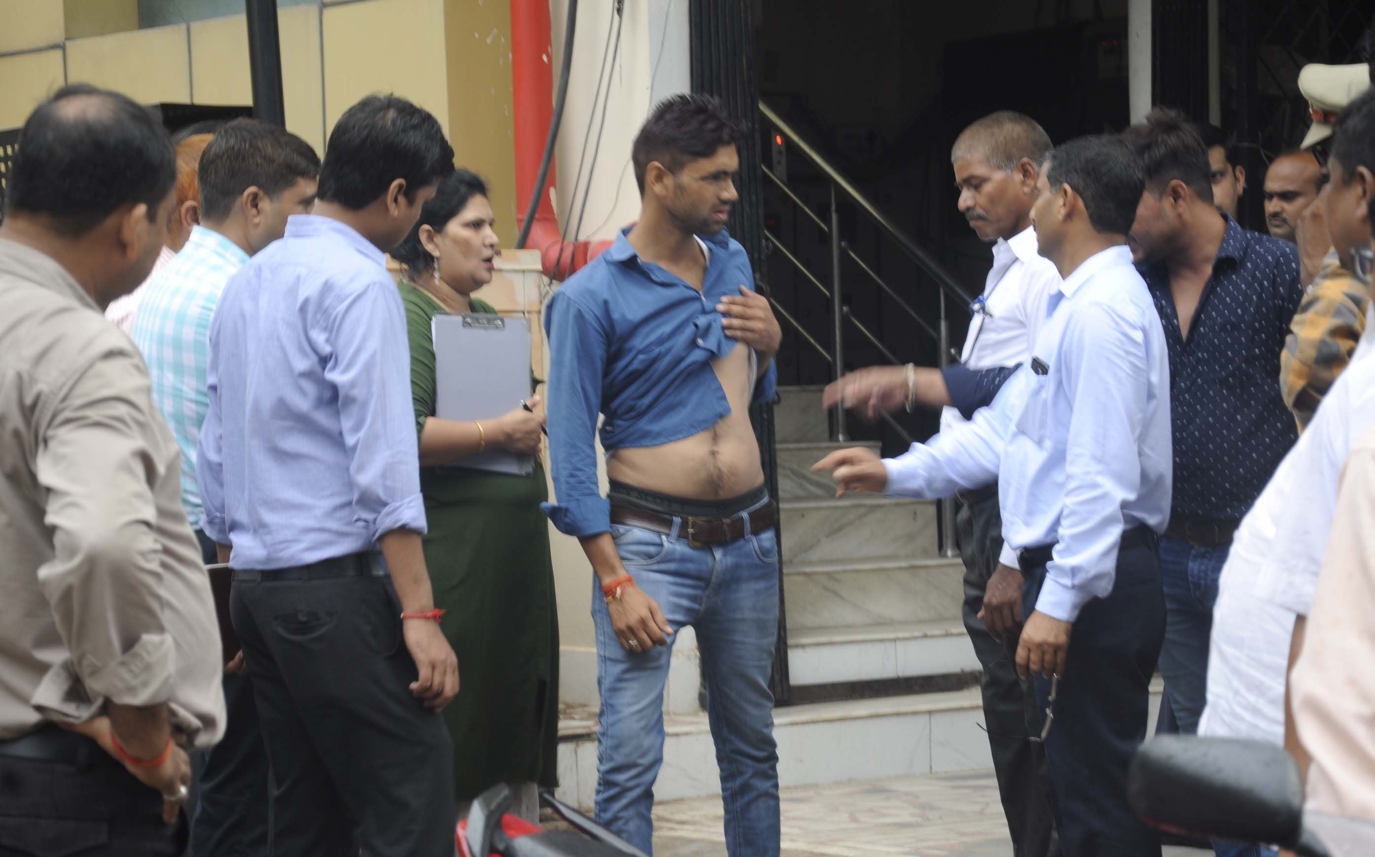 पूर्व कोतवाल की हत्या मामले में माडल शाप में गोली से घायल युवक से पूछताछ करते सीबीआई के अधिकारी।