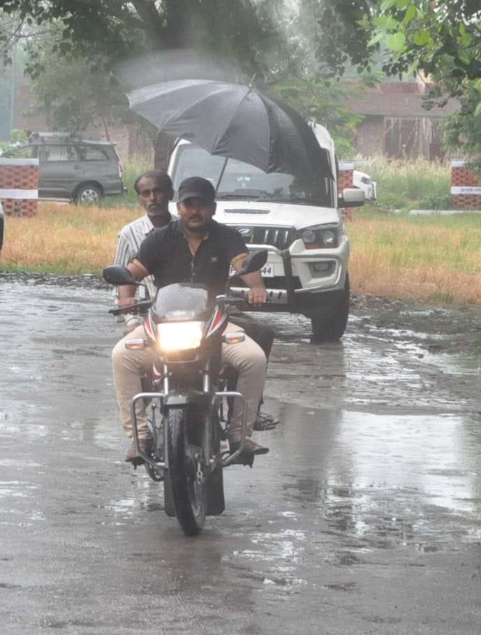 बुधवार को झमाझम बारिश के बीच दिन में बाइक की लाइट जलाकर छाता लगाकर जाता बाइक सवार। बुधवार को झमाझम बारिश के बीच दिन में बाइक की लाइट जलाकर छाता लगाकर जाता बाइक सवार।
