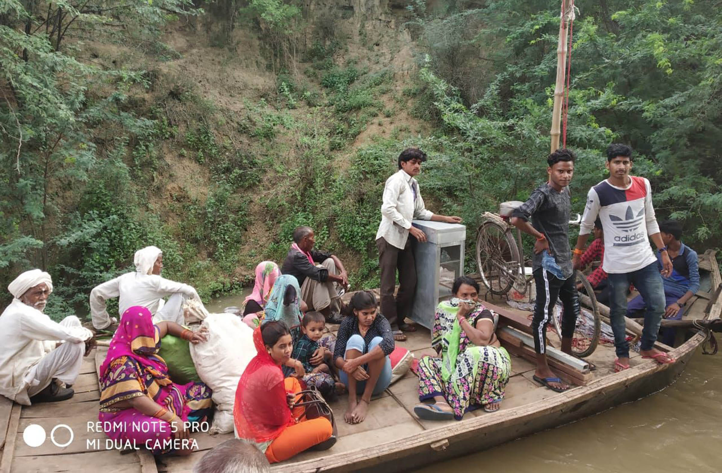 नाव से सुरक्षित स्थानों पर जाते बाढ़ प्रभावित।