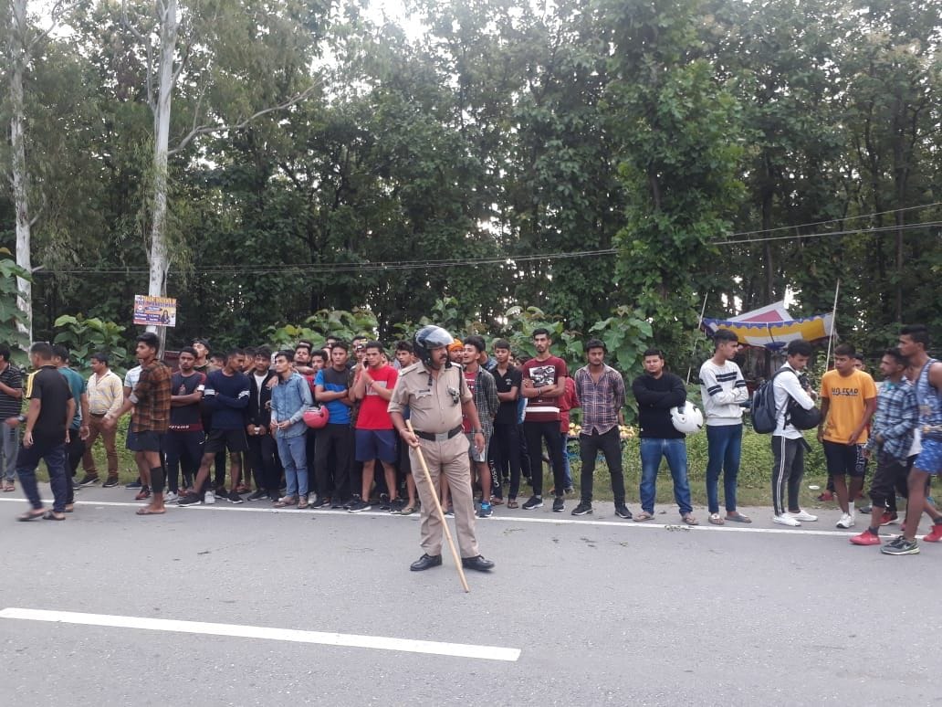 बनबसा में सेना भर्ती स्थल पर हाईवे किनारे खड़े युवाओं को नियंत्रित करता पुलिस कर्मी। बनबसा में सेना भर्ती स्थल पर हाईवे किनारे खड़े युवाओं को नियंत्रित करता पुलिस कर्मी।