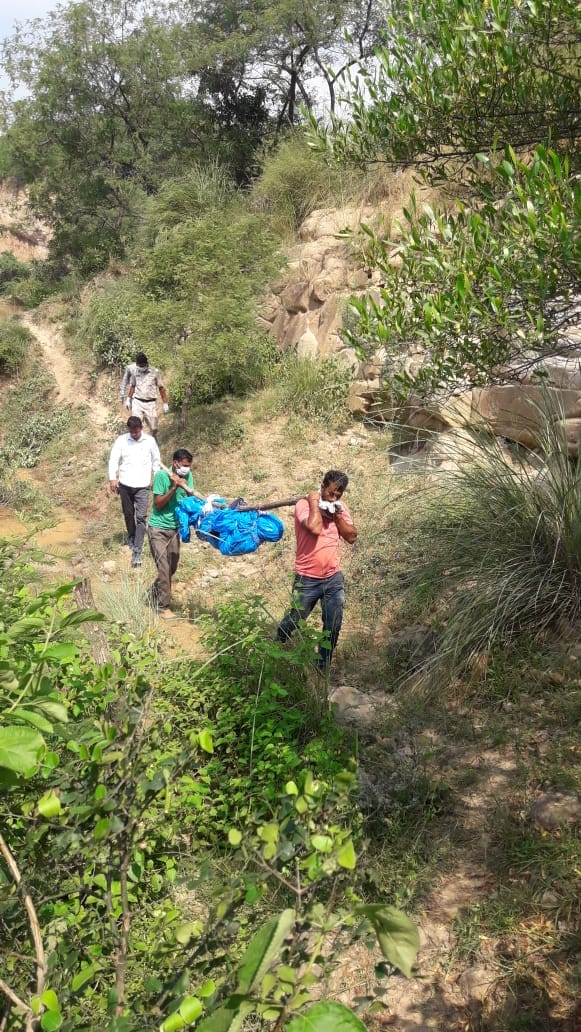 फोटो 1- जंगल से शव को बाहर निकालते ग्रामीण, कार्यवाही को अंजाम देते पुलिस के कर्मचारी, शव की जगह को म
