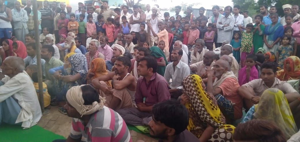 टिकरी गांव में राशन सामग्री लेने के लिए बैठे लोग टिकरी गांव में राशन सामग्री लेने के लिए बैठे लोग