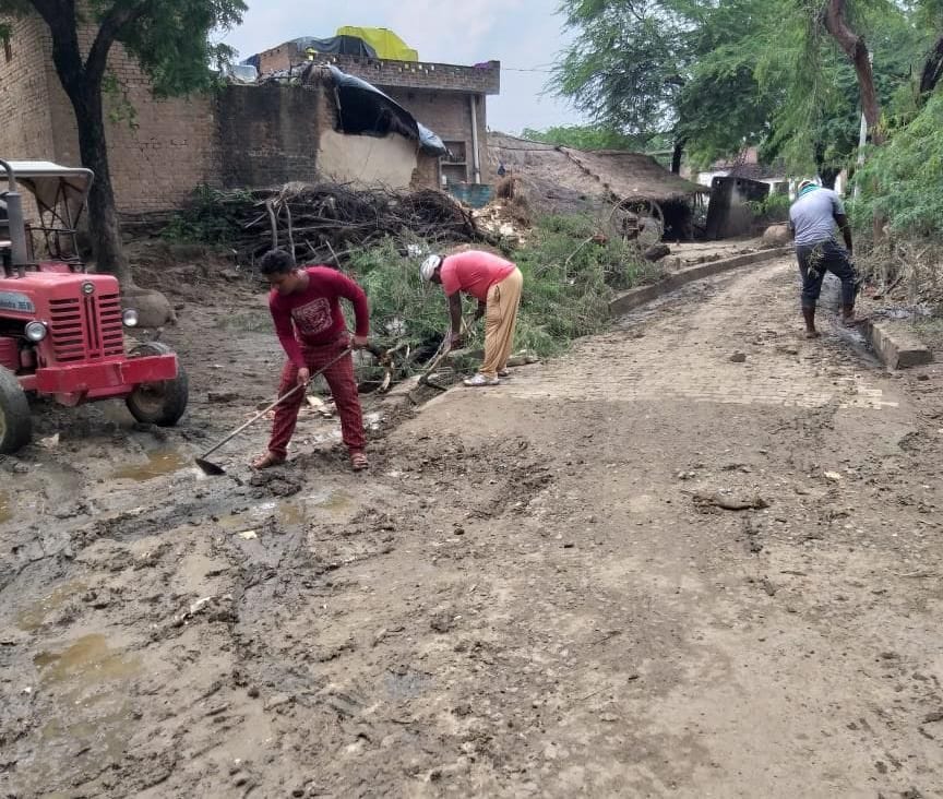 गुलोली में बाढ़ के बाद सफाई करते कर्मचारी गुलोली में बाढ़ के बाद सफाई करते कर्मचारी