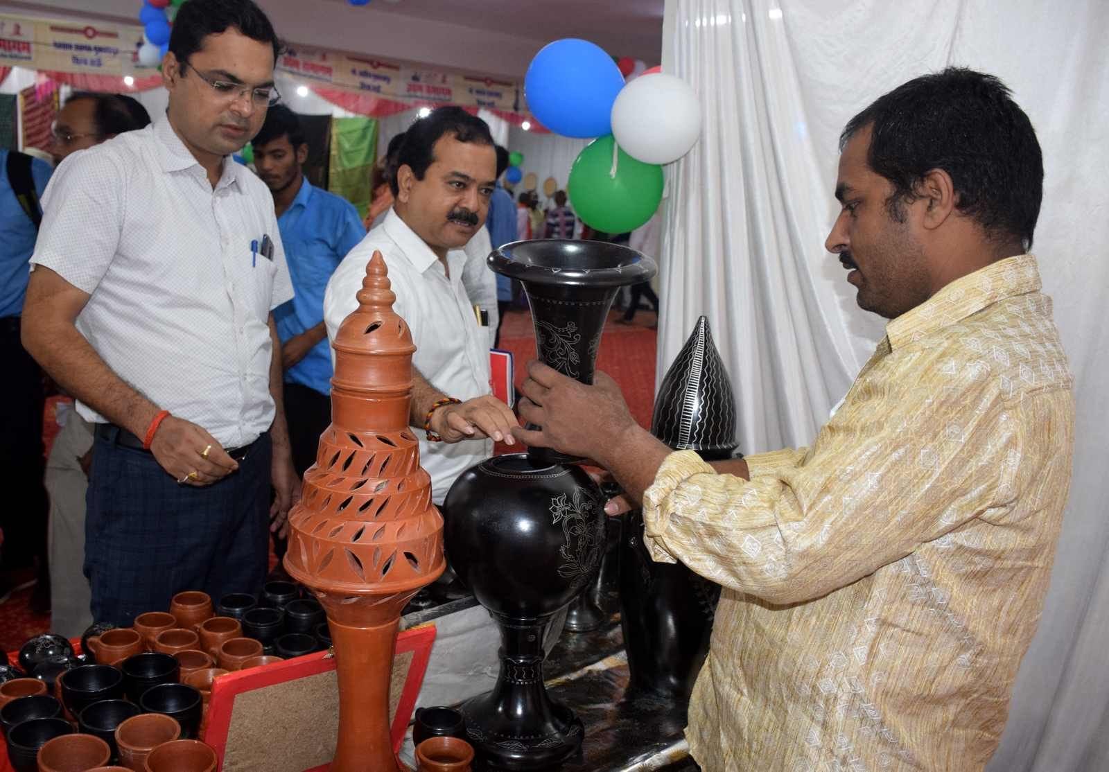 कलेक्ट्रेट पर उद्यम उद्योग एंव ओडीओपी प्रदर्शनी ब्लैक पाटरी के सामानों को देखते लोग।