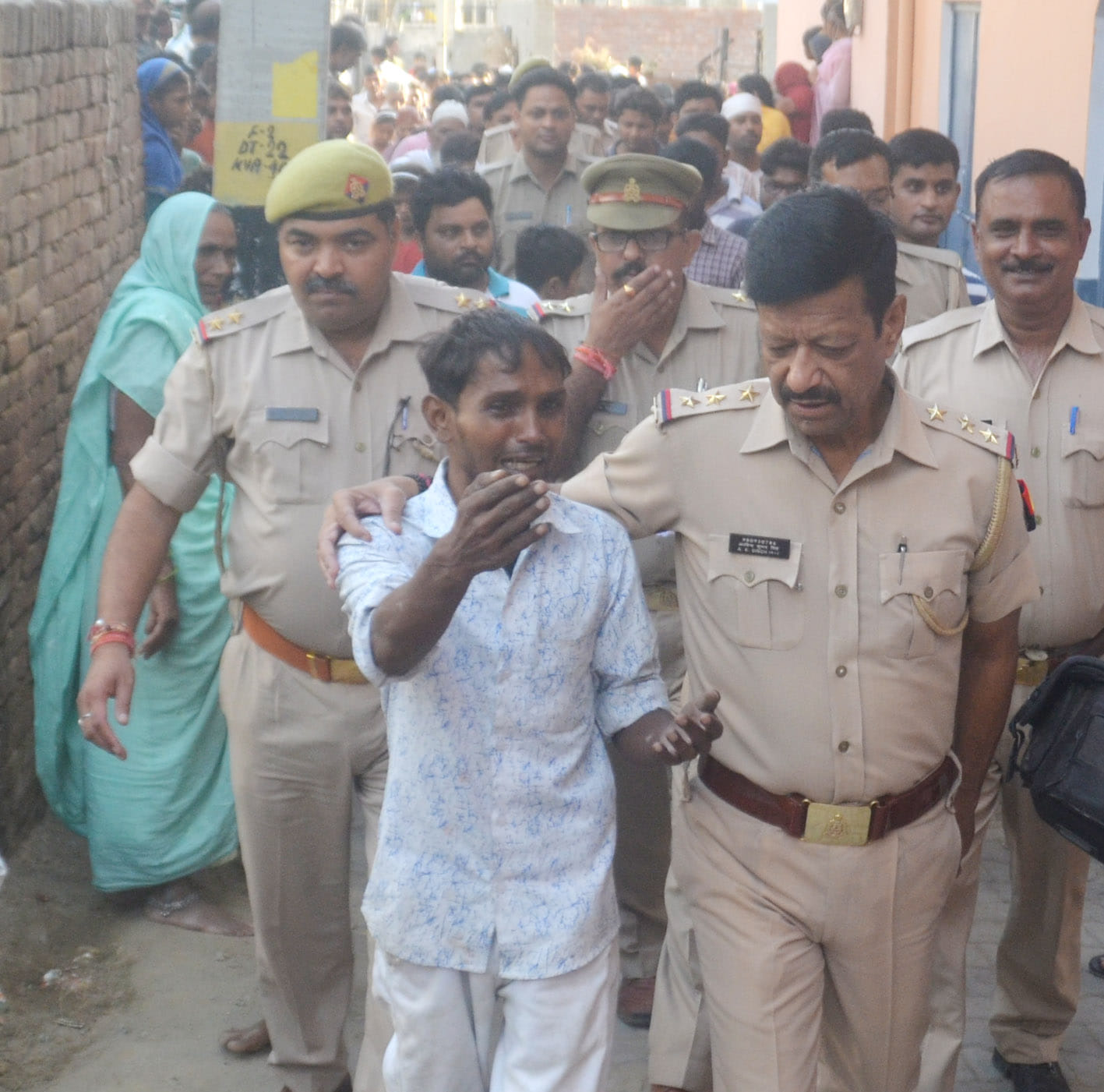 बागपत के यमुना रोड स्थित टावर पर चढ़े युवक सुभाष को ले जाते पुलिसकर्मी