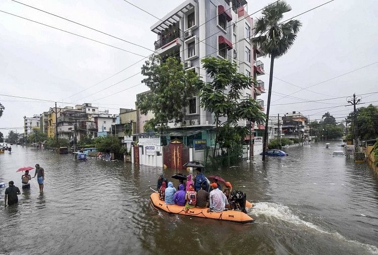 बाढ़ वाले इलाके से लोगों को सुरक्षित स्थानों पर ले जाते एनडीआरएफ के जवान