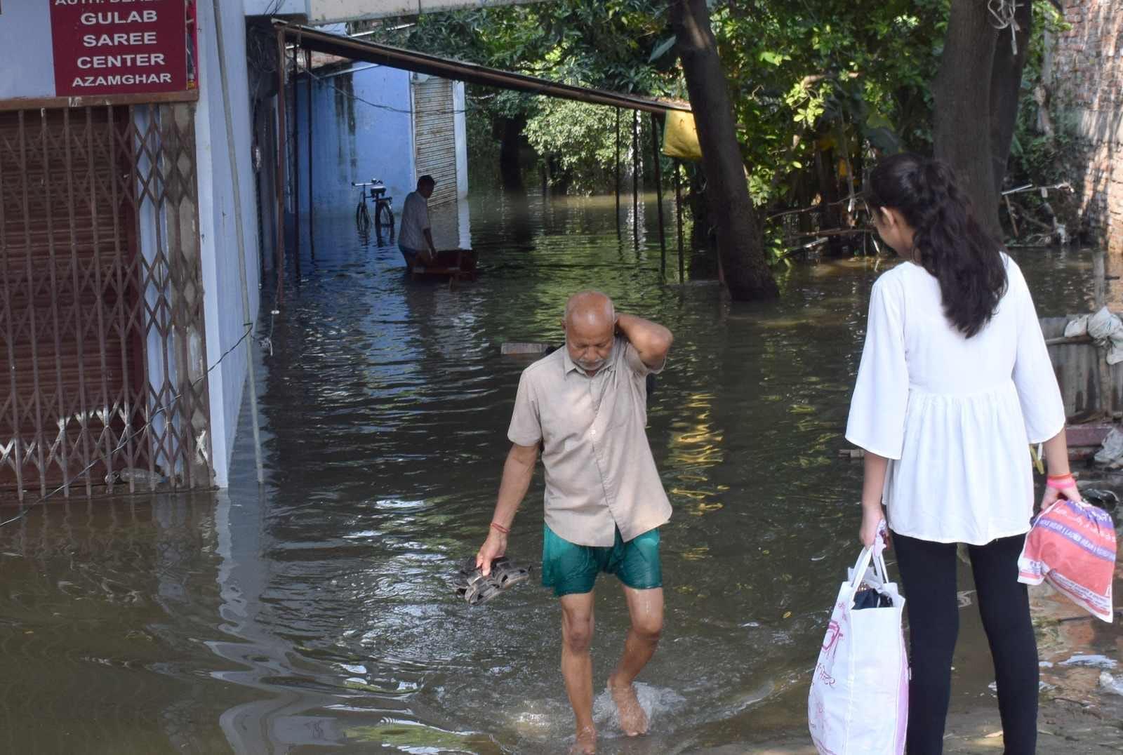 शहर के मड़या जयरामपुर में तमसा के पानी में से घिरे घर से अपने सामानों को निकालते लोग। शहर के मड़या जयरामपुर में तमसा के पानी में से घिरे घर से अपने सामानों को निकालते लोग।