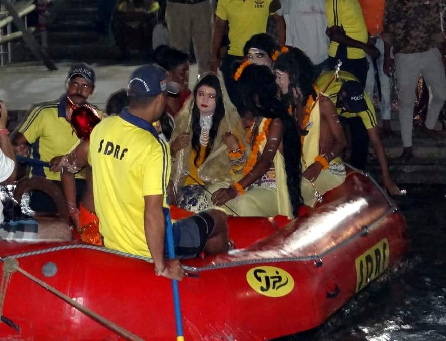 25 त्रिवेणी घाट पर राफ्ट पर इस तरह राम, लक्ष्मण और सीता के कलाकारों को गंगा नदी पार कराते एसडीआरएफ क? 25 त्रिवेणी घाट पर राफ्ट पर इस तरह राम, लक्ष्मण और सीता के कलाकारों को गंगा नदी पार कराते एसडीआरएफ क?