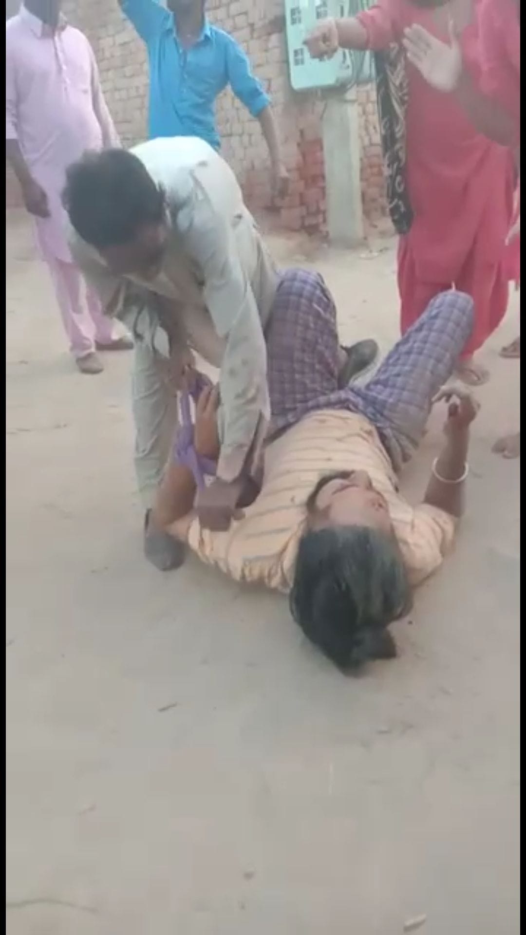 पुलिस कर्मचारी की पिटाई करते हुए पारिवारिक सदस्य। पुलिस कर्मचारी की पिटाई करते हुए पारिवारिक सदस्य।