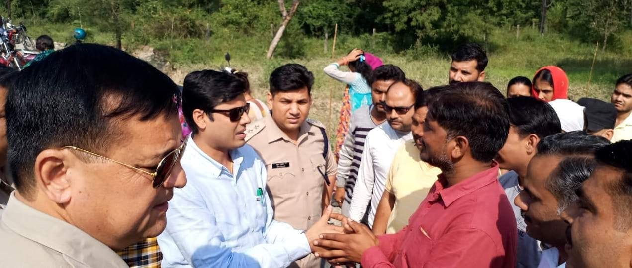 शीशमबाड़ा में आमरण अनशन पर बैठे युवक सतपाल से वार्ता करते एसडीएम कौस्तुभ मिश्र।