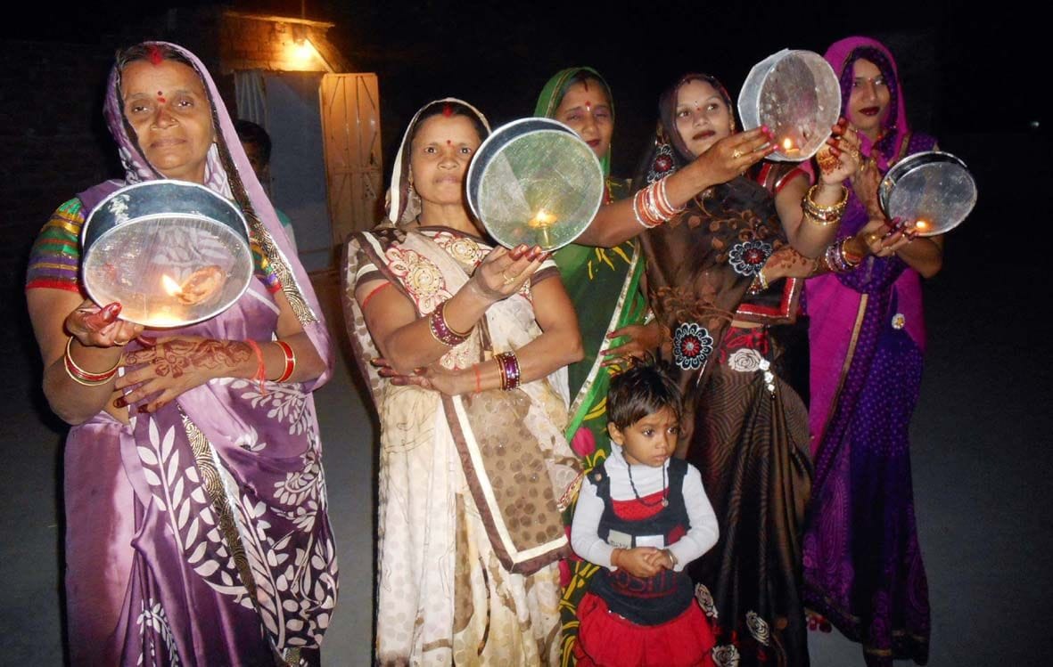 छलनी से पतियों का दर्शन करती सुहागिने