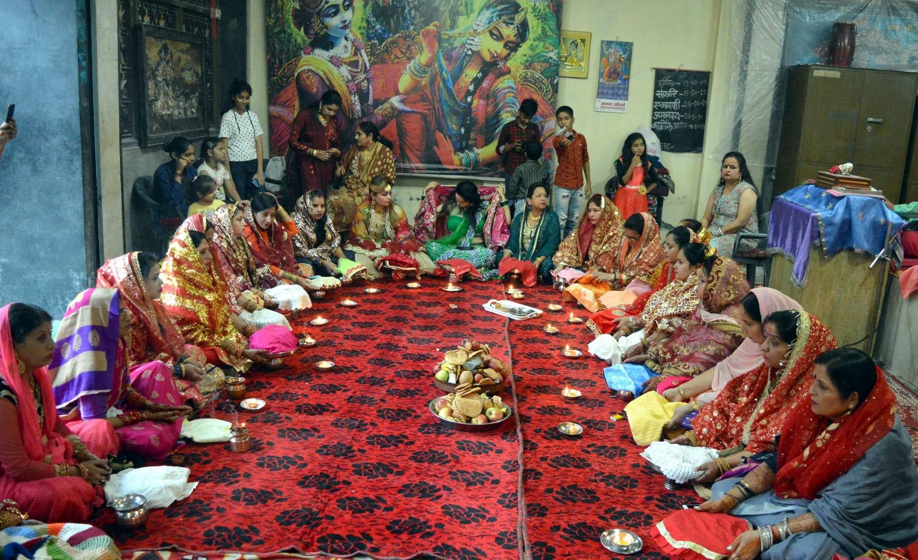 करवाचौथ पर गीता भवन मंदिर में सामूहिक कथा सुनतीं महिलाएं।