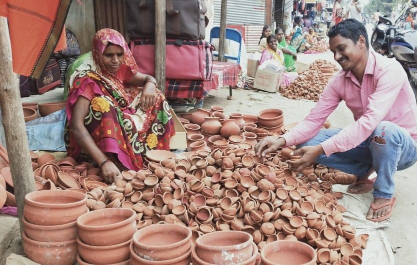 दुद्धी बाजार में मिट्टी से बने दीपों की खरीदारी करते लोग