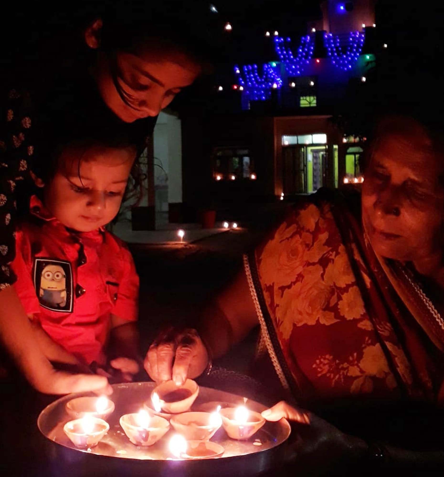 दिलीपपुर में दीपावली पर घर में दीप जलाती महिला।