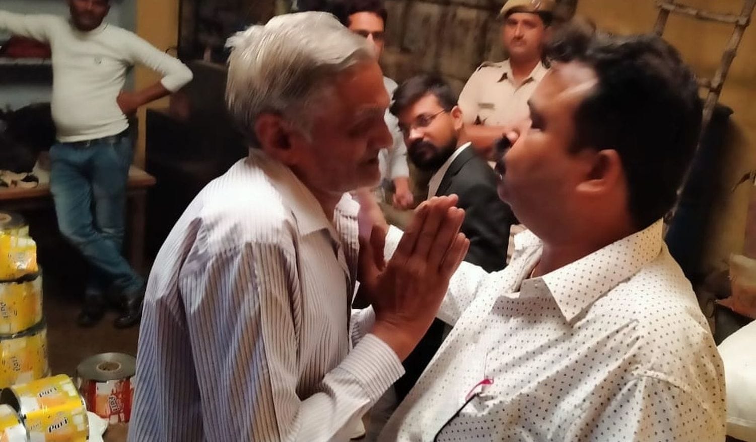  कंपनी के अधिकृत्त अधिकारी के सामने हाथ जोड़ता बुजुर्ग।