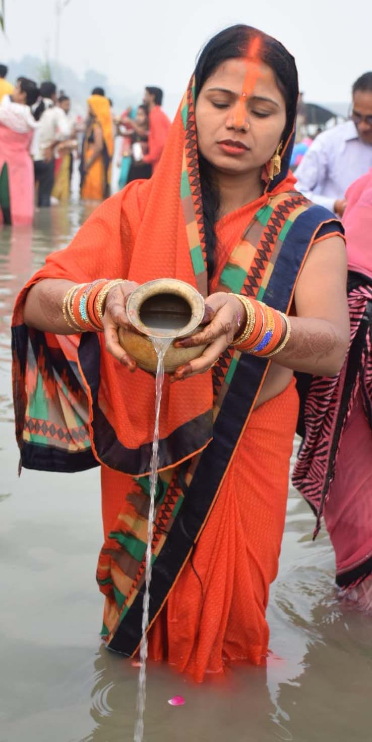 डाला छठ पर सूर्योदय पर अर्घ देती महिला। डाला छठ पर सूर्योदय पर अर्घ देती महिला।