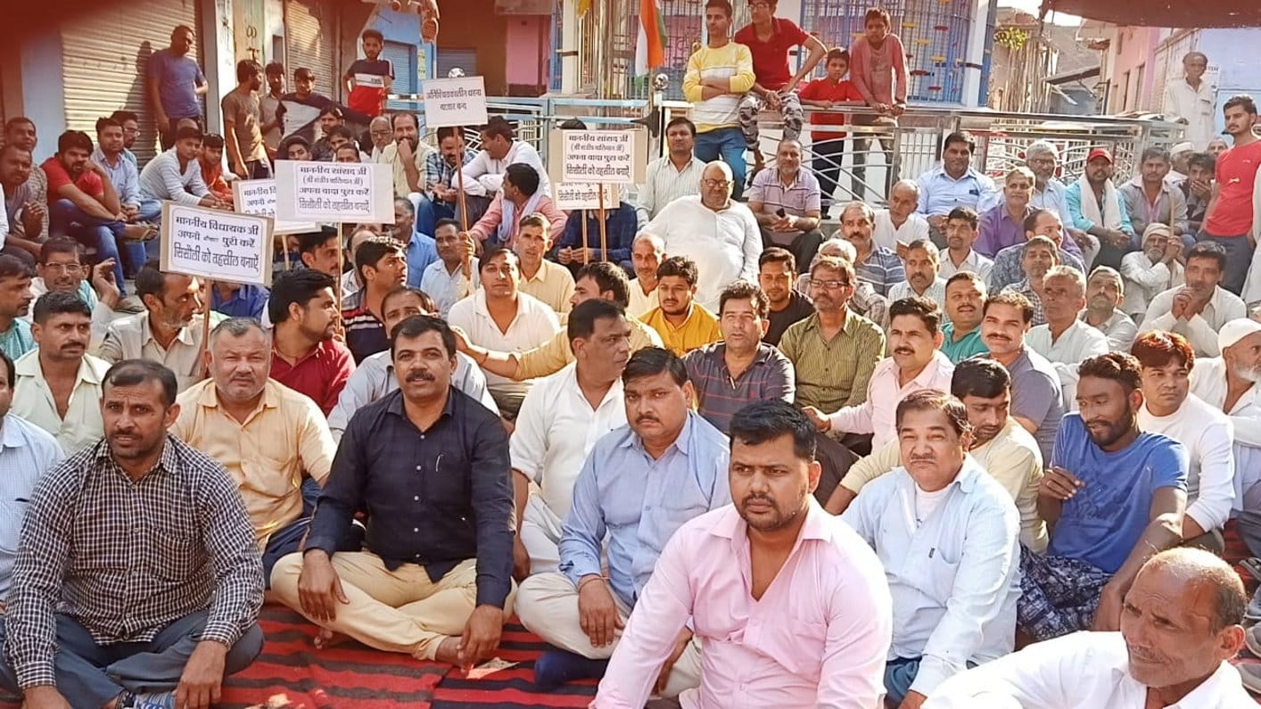 सिसौली के होली चौक पर धरना देते कसबावासी। सिसौली के होली चौक पर धरना देते कसबावासी।