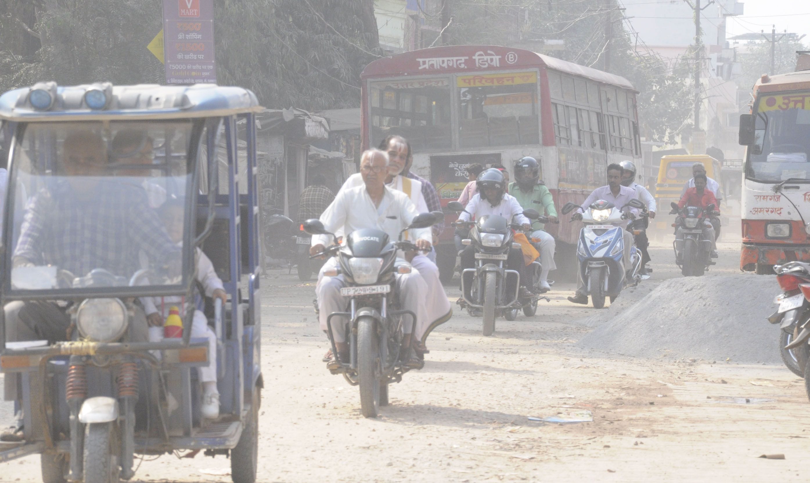 रोडवेज बस अड्डा जाने वाली जर्जर सड़क पर उड़ रही धूल।