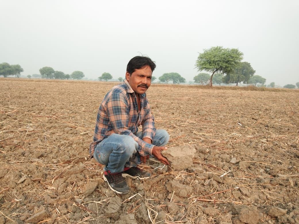 मोहम्मदाबाद में बिना पानी सूखे पड़े खेत दिखाता किसान मोहम्मदाबाद में बिना पानी सूखे पड़े खेत दिखाता किसान