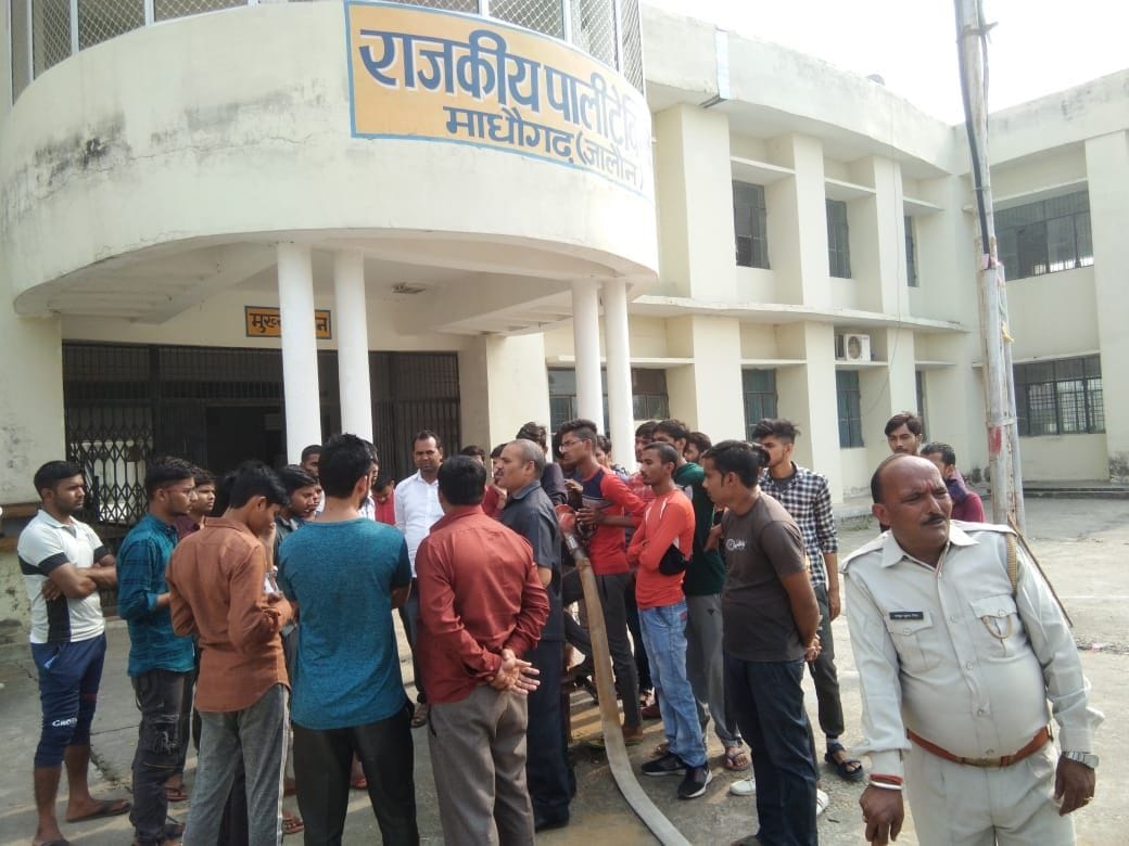 पॉलीटेक्निक के बाहर छात्रों को समझाते अधिकारी पॉलीटेक्निक के बाहर छात्रों को समझाते अधिकारी