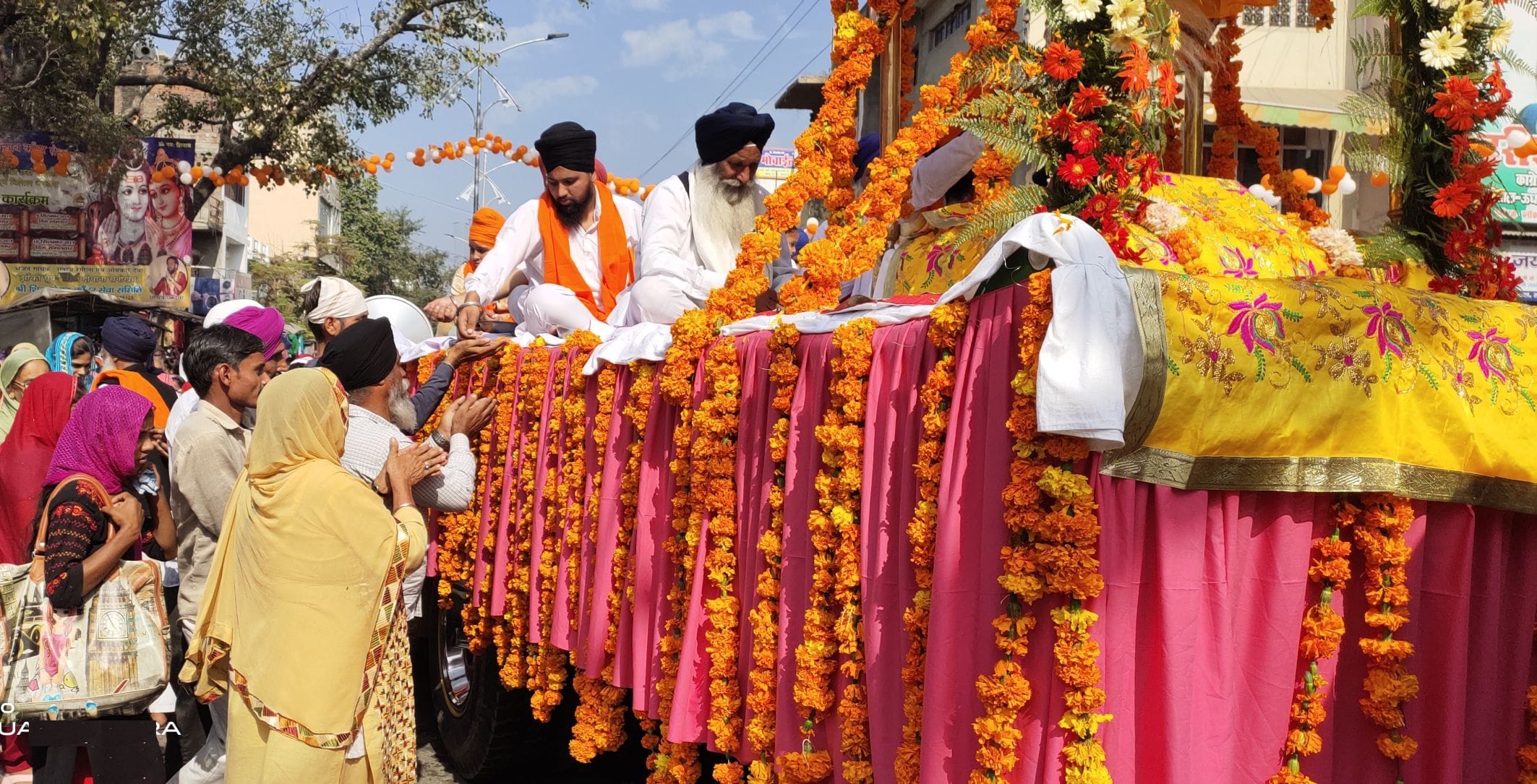 सितारगंज में नगर कीर्तन के दौरान सजी पालकी से प्रसाद लेती संगत। सितारगंज में नगर कीर्तन के दौरान सजी पालकी से प्रसाद लेती संगत।