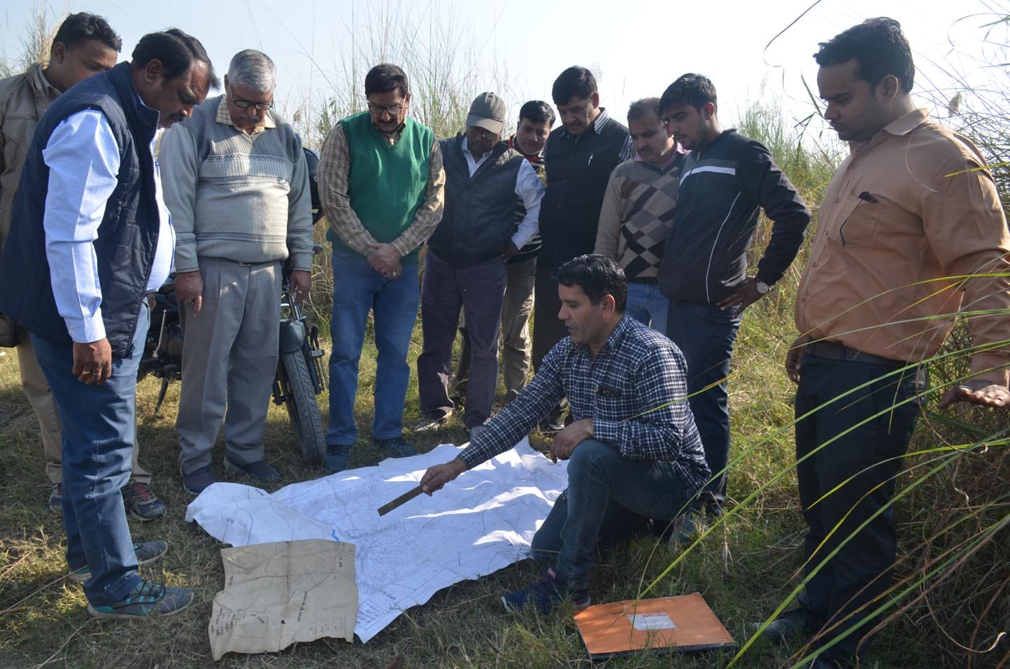 गंगा खादर में नक्शा लेकर भूमि चिन्हित करने को आंकलन करते अधिकारी। गंगा खादर में नक्शा लेकर भूमि चिन्हित करने को आंकलन करते अधिकारी।