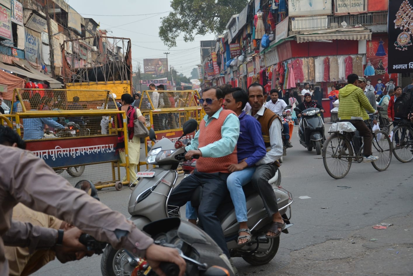 शिवचौक पर बिना हेलमेट ट्रिपल राइडिंग करते एक्टिवा सवार। एक्टिवा की आगे की नंबर प्लेट पर लिखा हुआ 