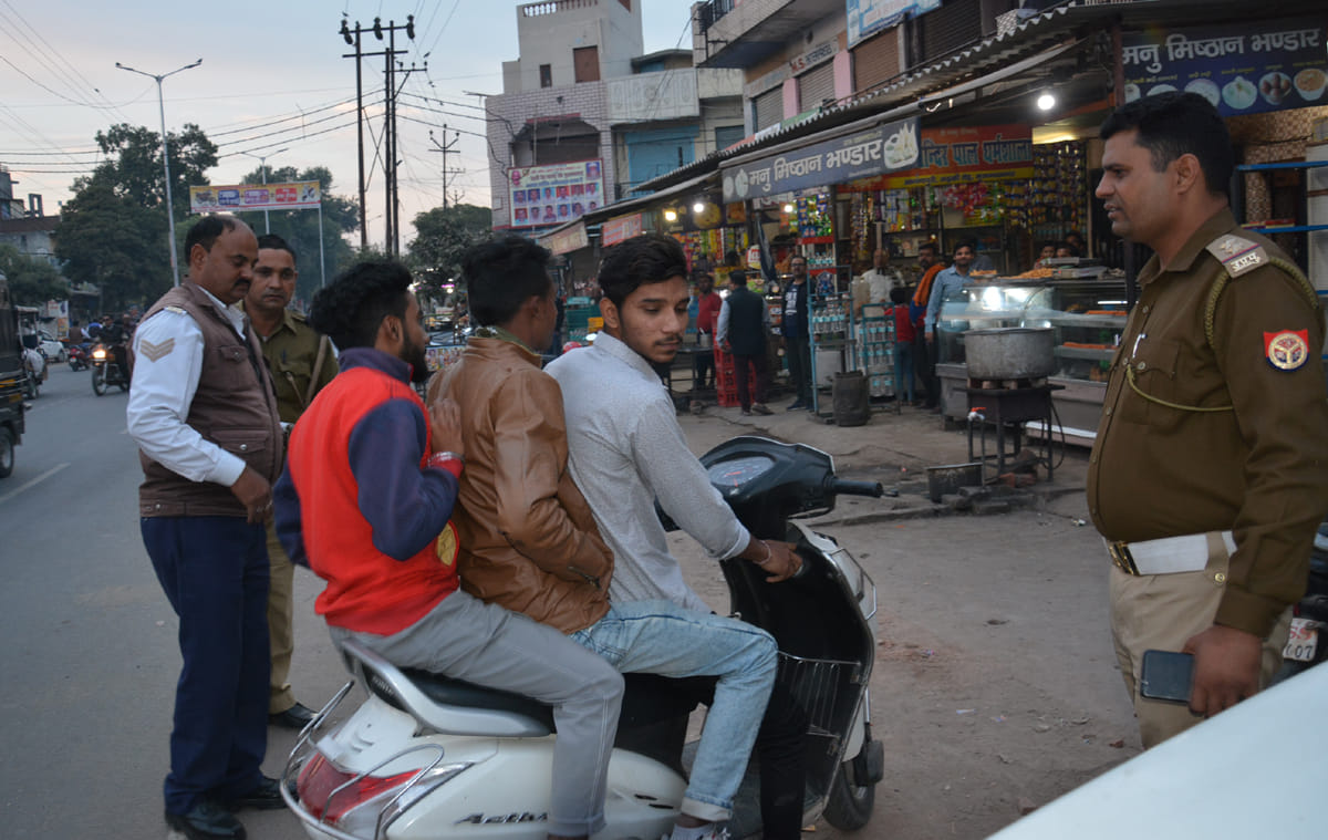 रुडकी रोड पर ट्रिपल राईडिग करते युवको को रोकते यातायात कर्मी। रुडकी रोड पर ट्रिपल राईडिग करते युवको को रोकते यातायात कर्मी।