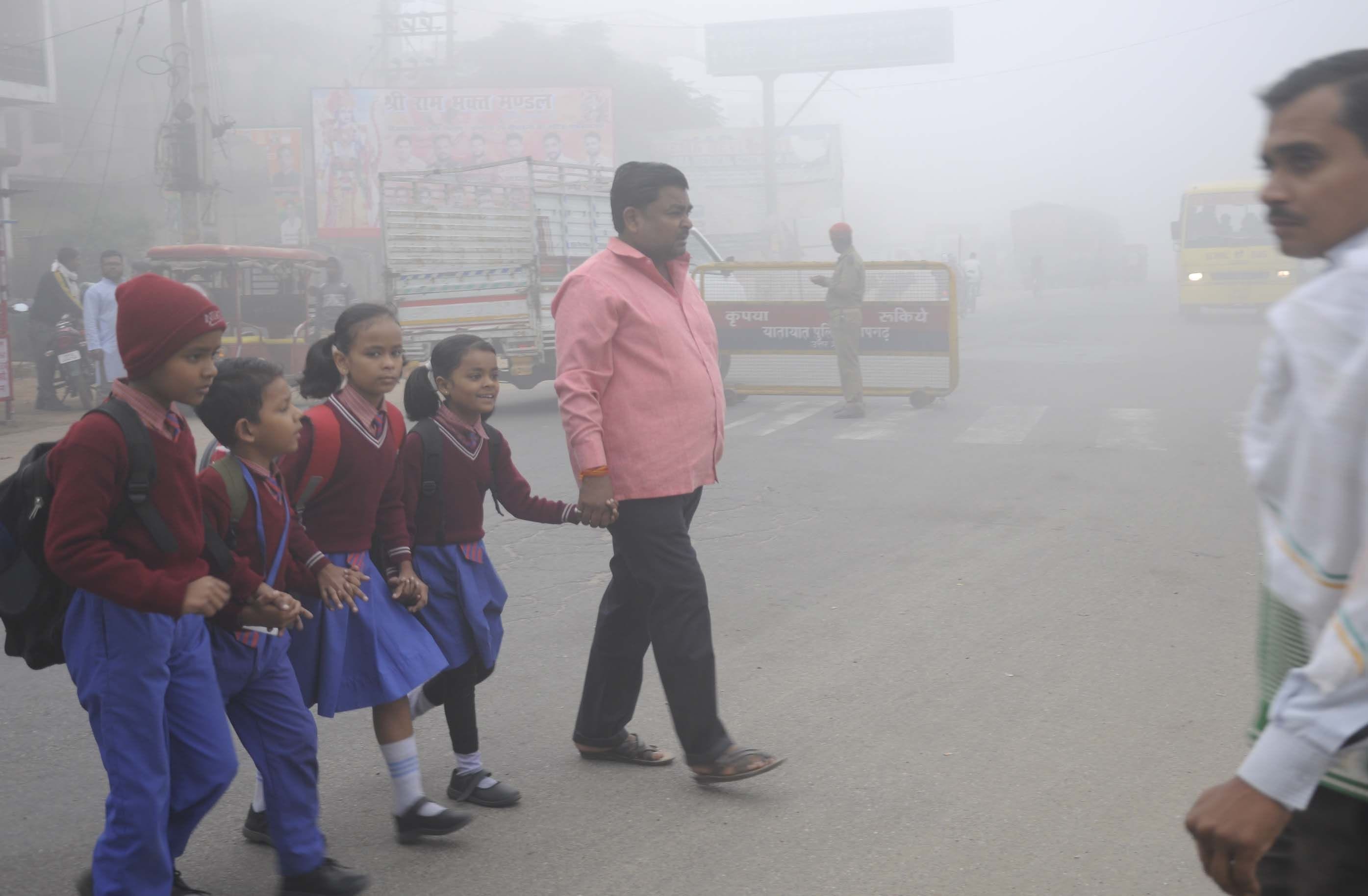 मंगलवार को सुबह घने कोहरे में बच्चों को स्कूल जाने के लिए सड़क पार कराता युवक। मंगलवार को सुबह घने कोहरे में बच्चों को स्कूल जाने के लिए सड़क पार कराता युवक।