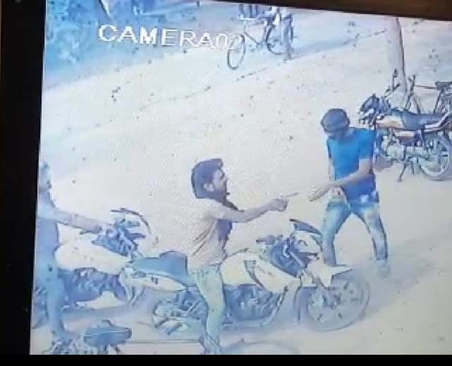 जेठवारा थाने के सराय देवराय में खाद गोदाम में लूट के बाद बाहर निकला बदमाश साथी को तमंचा देते हुए।